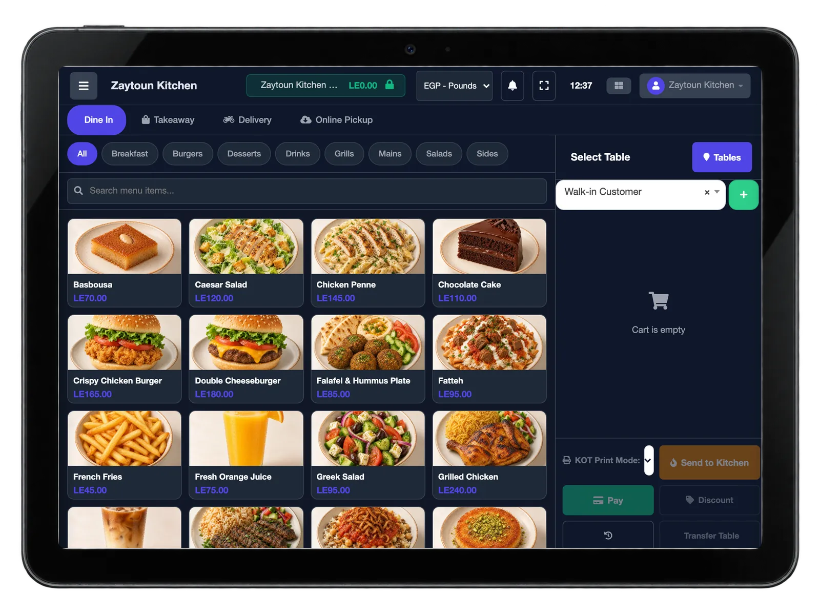 A countertop terminal showing the restaurant point of sale: order-type tabs for dine in, takeaway, delivery and online pickup, category filters, and a menu grid of photographed dishes, with an empty cart and table selection beside it.